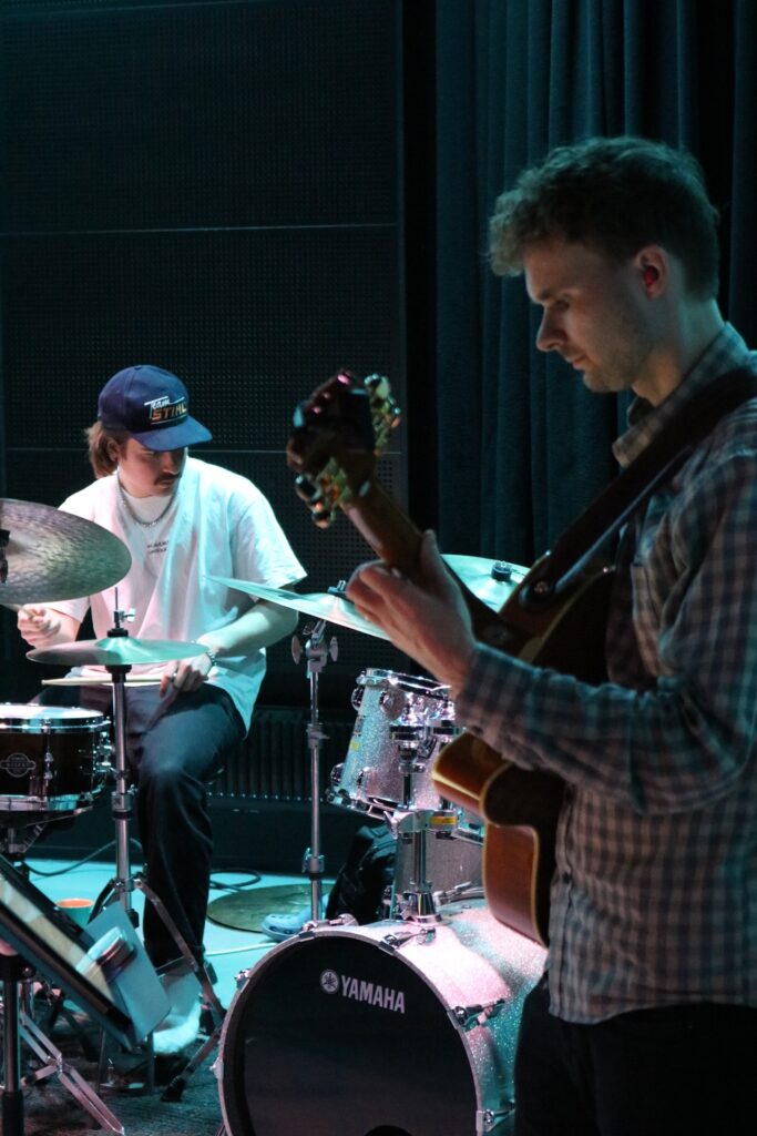 Kitaristi ja rumpali soittavat omia soittimiaan.