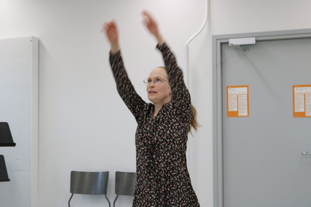 Henkilö nostaa kätensä kohti kattoa.