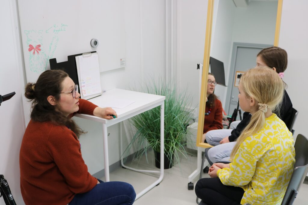 Opettaja ja kaksi oppilasta tunnilla.